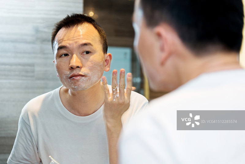 年轻亚洲男子刮胡子图片素材