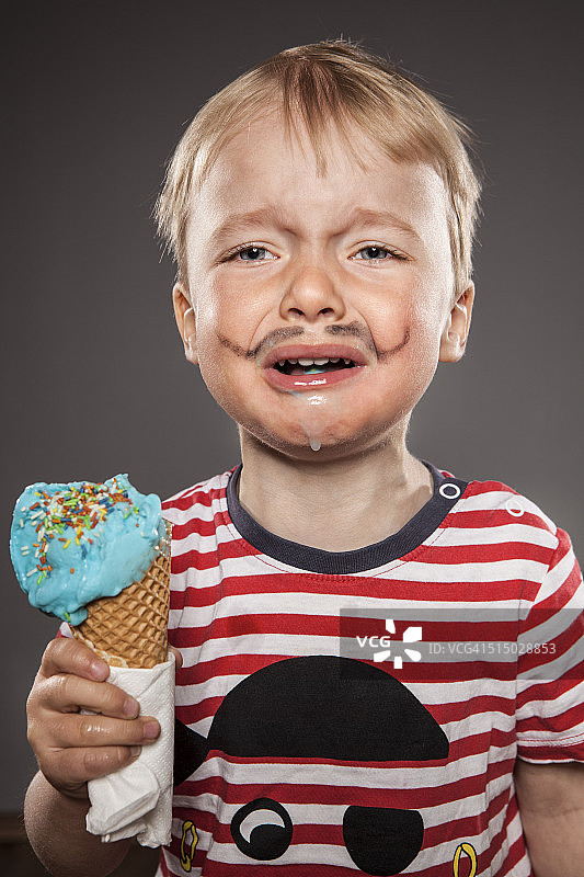 画像的哭泣的小男孩涂着胡子和冰淇淋图片素材