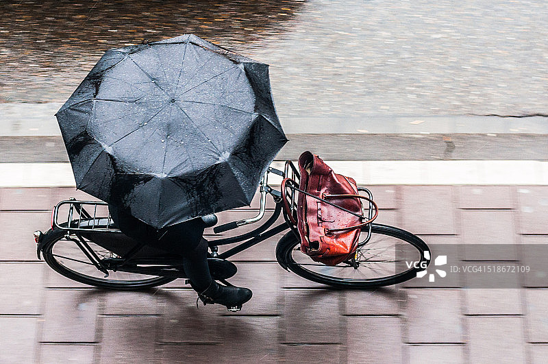 骑自行车的人用伞图片素材