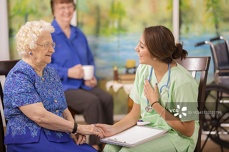 拉丁，女医生在养老院看望老年妇女病人。图片素材