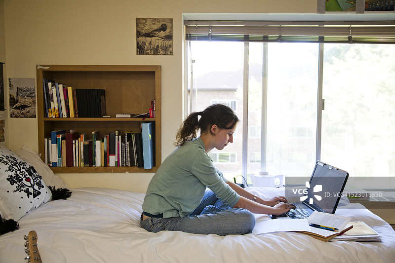 女大学生在宿舍里用电脑工作图片素材