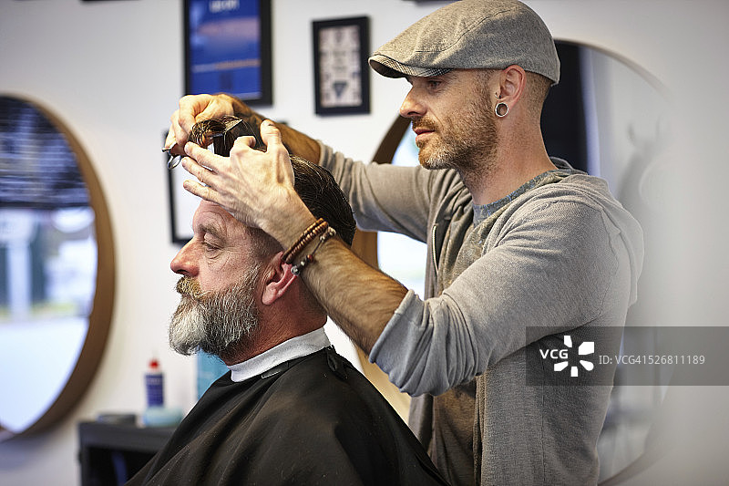 男性发型师为客户理发图片素材