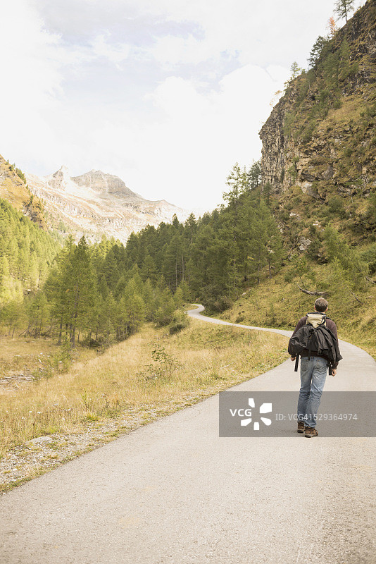 一个成熟的徒步旅行者走在山路上的后视图，奥地利阿尔卑斯山，卡林西亚，奥地利图片素材