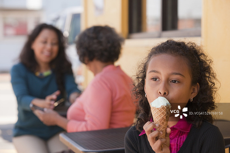 西班牙女孩和她的母亲和祖母在咖啡馆吃冰淇淋图片素材