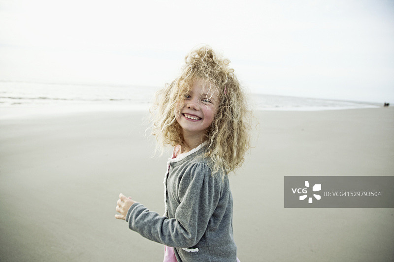 快乐的金发女孩的肖像(5-6)在海滩上图片素材