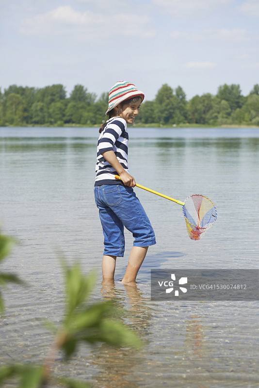 德国巴伐利亚，一个女孩在湖里钓鱼图片素材
