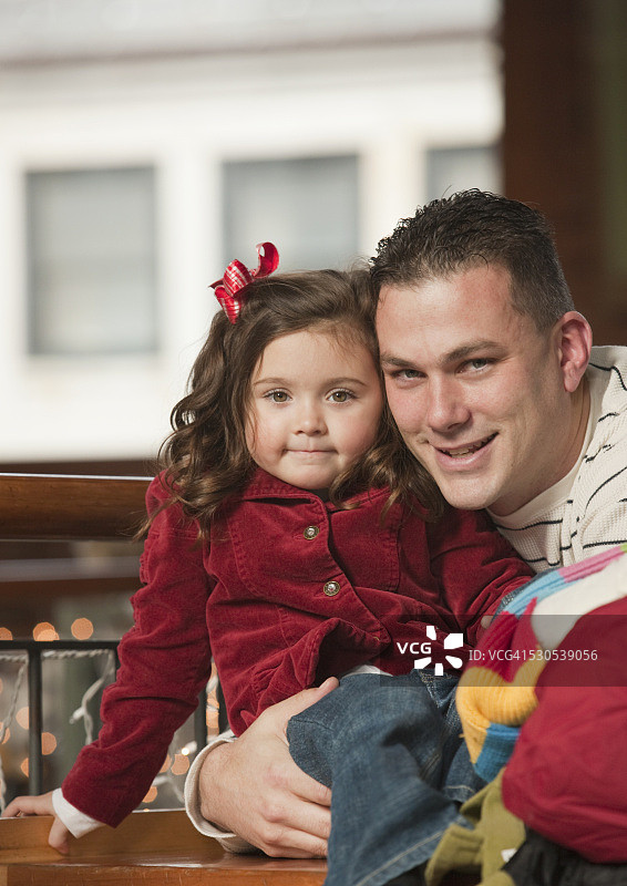 一个男人微笑着和他的女儿在假日购物的肖像图片素材