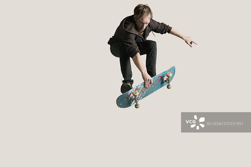 滑板手抓着空中的滑板图片素材