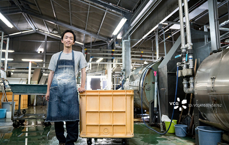 满意的工人站在一个大型服装洗涤设施图片素材