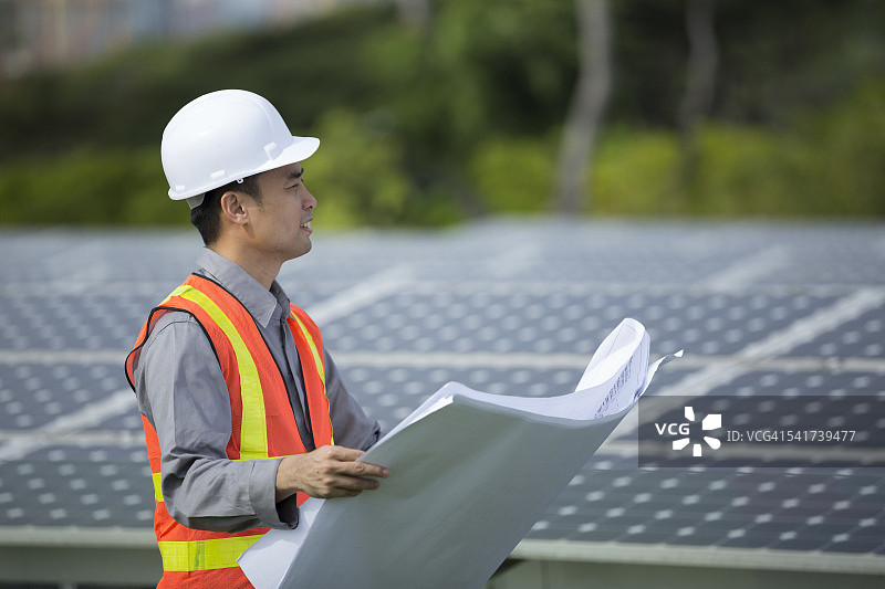 亚洲工人在现场检查太阳能电池板图片素材