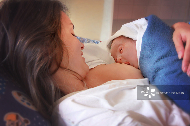 年轻的母亲正在母乳喂养她刚出生的婴儿图片素材
