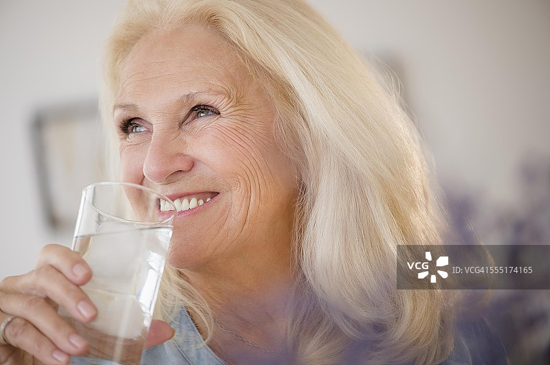年长妇女喝水的肖像图片素材