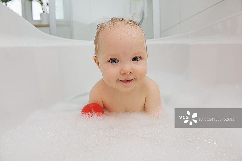 在浴缸里微笑的女婴的肖像图片素材