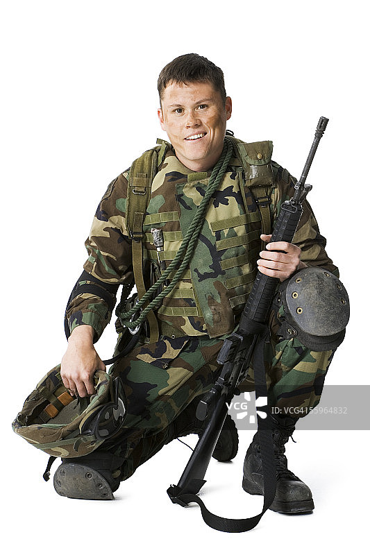 一个士兵的肖像，蜷伏着，拿着步枪和头盔图片素材