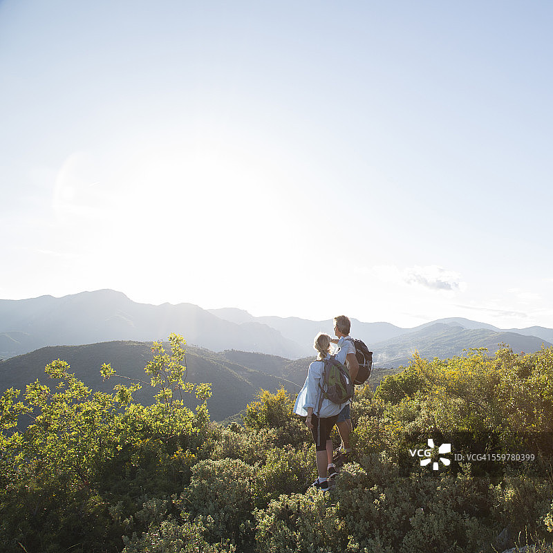一对徒步旅行的夫妇从森林里眺望小山图片素材