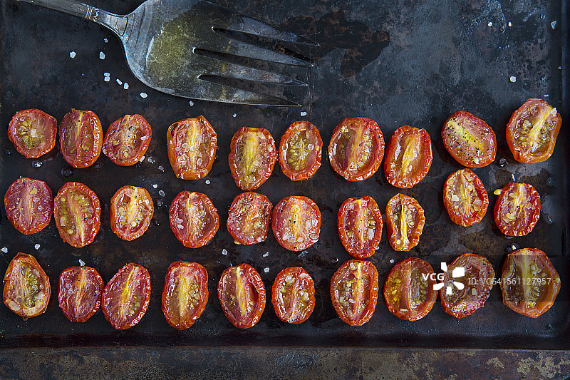 俯视烤罐上的一排排减半的烤番茄图片素材