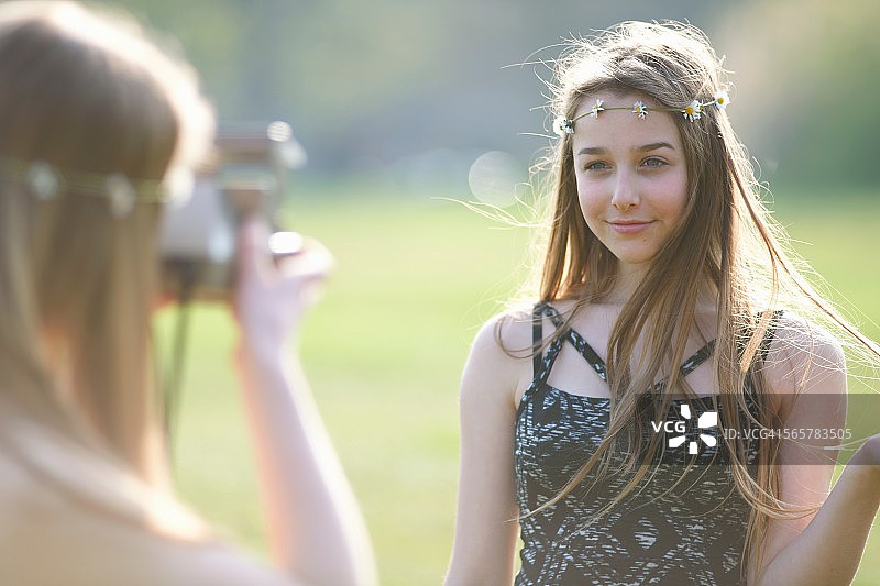 十几岁的女孩在公园用即时相机拍摄最好的朋友图片素材