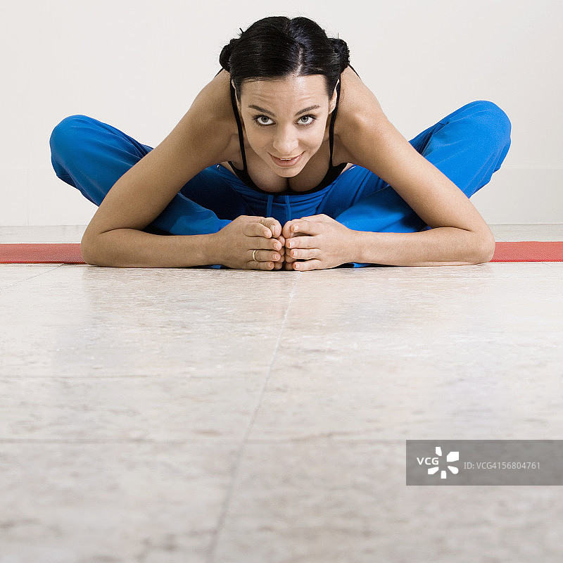 一个年轻女子在运动垫上运动的肖像图片素材