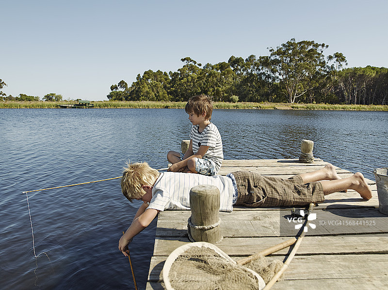 两个男孩在湖边钓鱼图片素材