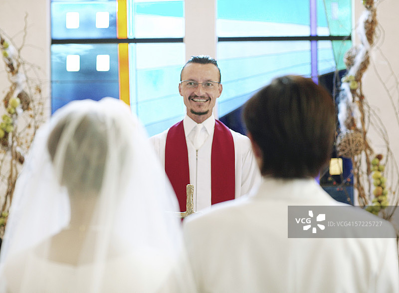 美国牧师对着新娘和新郎微笑图片素材
