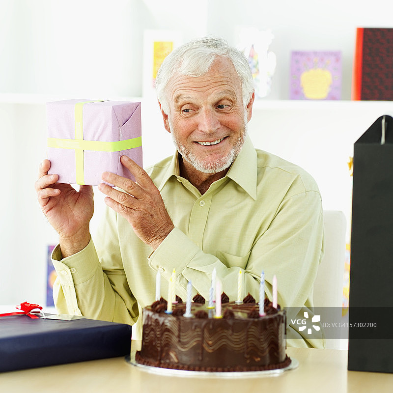 一个老人举着生日礼物的特写图片素材