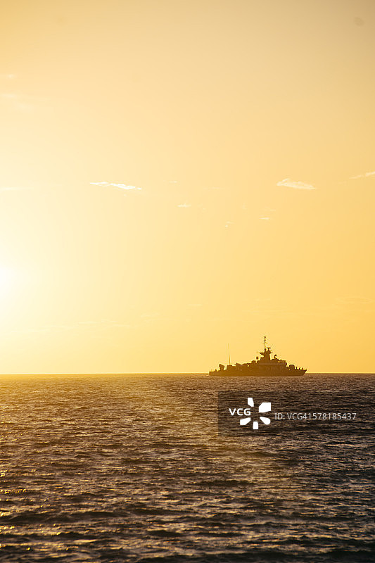 希腊，日落时从帕罗斯看到地平线上战舰的剪影图片素材