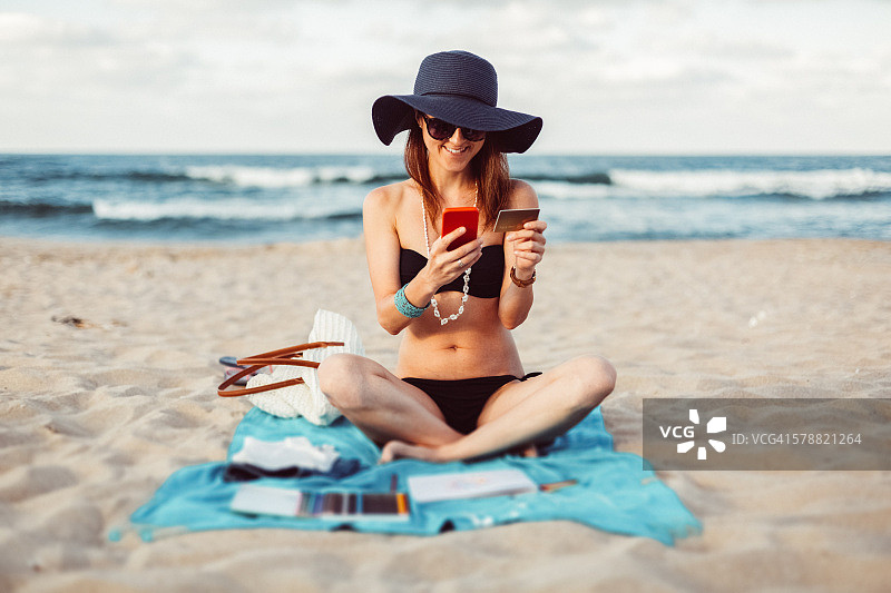 在海滩上用信用卡购物的女人图片素材