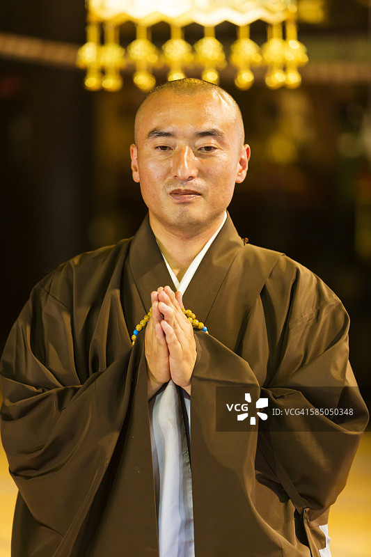 在传统日本寺庙里祈祷的佛教僧侣图片素材