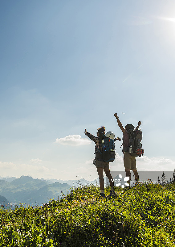 奥地利，蒂罗尔，坦海默塔尔，欢呼的年轻夫妇站在山道上看风景图片素材