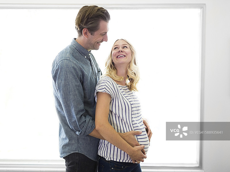 丈夫拥抱怀孕的妻子图片素材