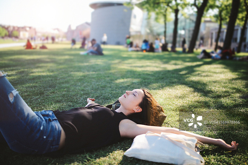 年轻女子在阿姆斯特丹城市公园休息图片素材