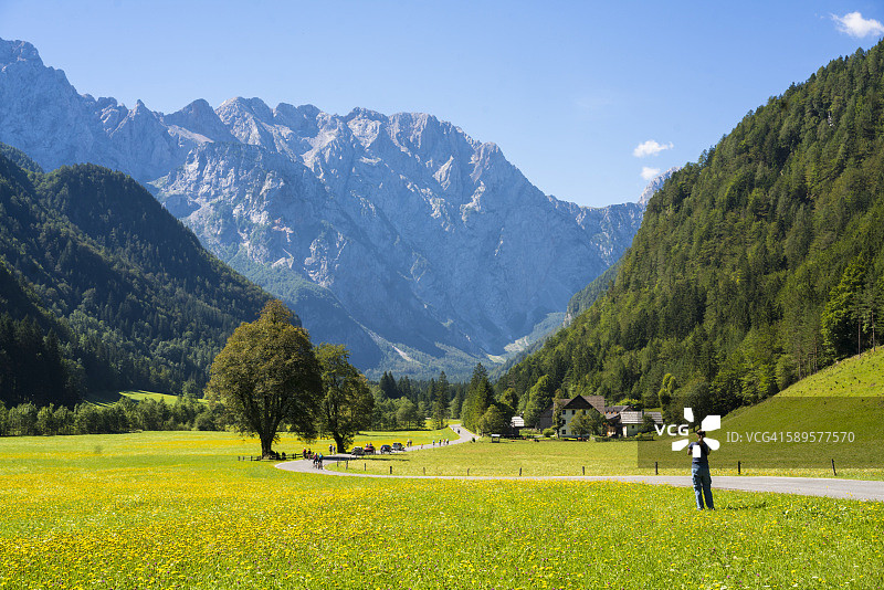 一个女人正在拍摄美丽的洛加尔山谷，斯洛文尼亚图片素材