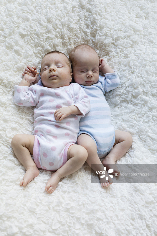 刚出生的双胞胎并排睡觉的肖像图片素材