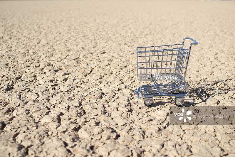 迷你购物车在沙漠干燥的湖床上图片素材