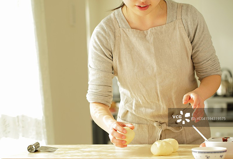 年轻女子在厨房做面包图片素材