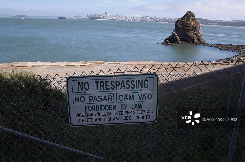 背景是美国加州旧金山的天际线上，“请勿擅自进入”的标志图片素材