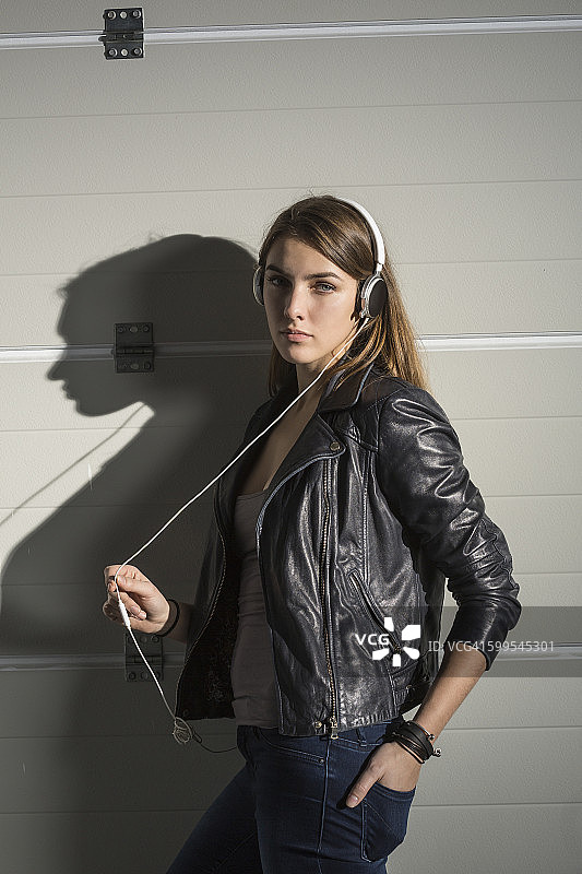 自信的女人在音乐工作室通过耳机听音乐的肖像图片素材