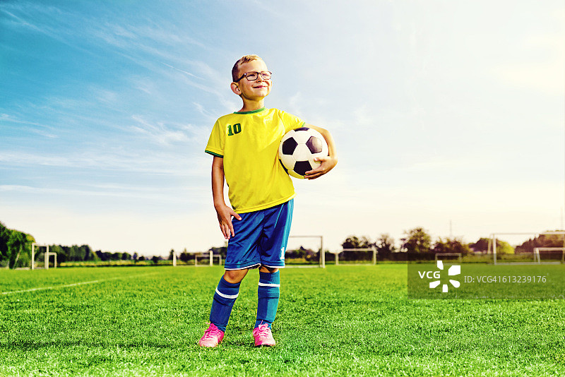 足球男孩的肖像穿着运动服拿着一个足球图片素材