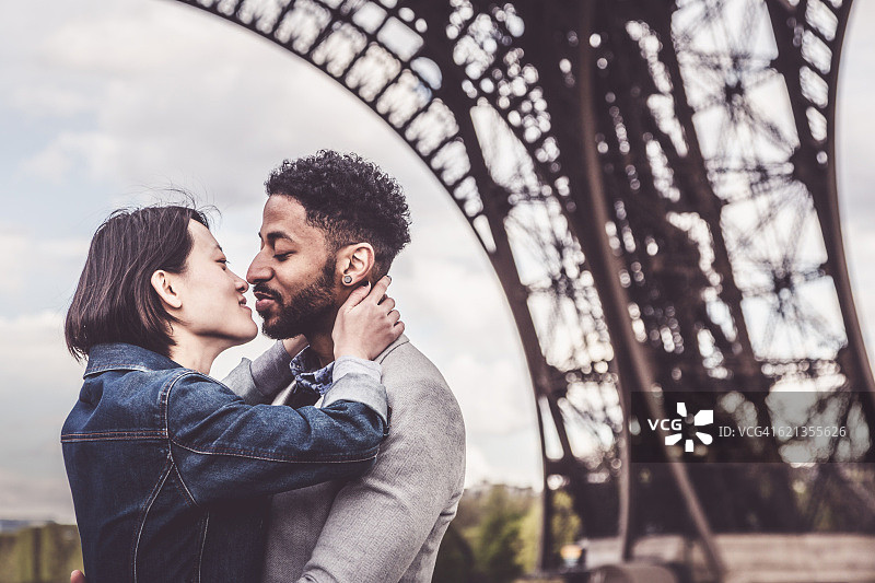 多民族夫妇有乐趣在巴黎附近的埃菲尔铁塔图片素材