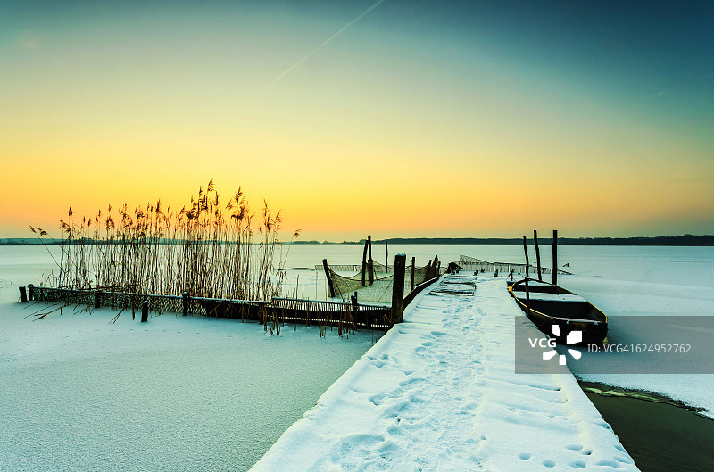 日落时结冰的雪湖和码头(勃兰登堡/德国)图片素材