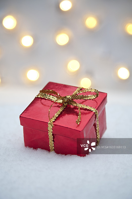 红色礼物在雪与灯图片素材