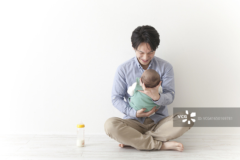 日本男人用摇篮抱着婴儿图片素材