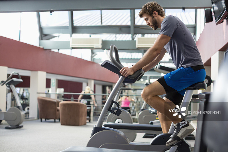 男人在健身房的旋转机器上锻炼图片素材