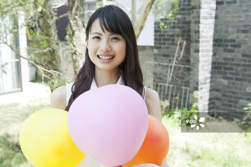 一个年轻女子拿着气球的肖像图片素材