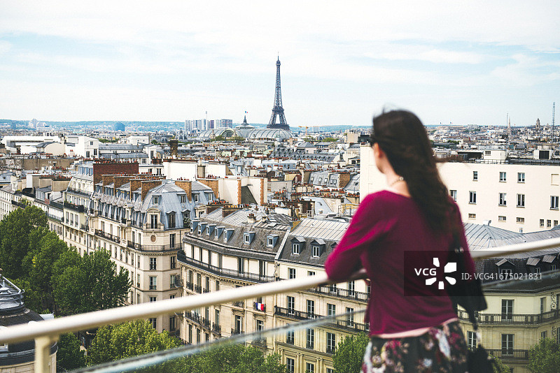 法国，巴黎，一个女人享受着以埃菲尔铁塔为背景的巴黎美景图片素材