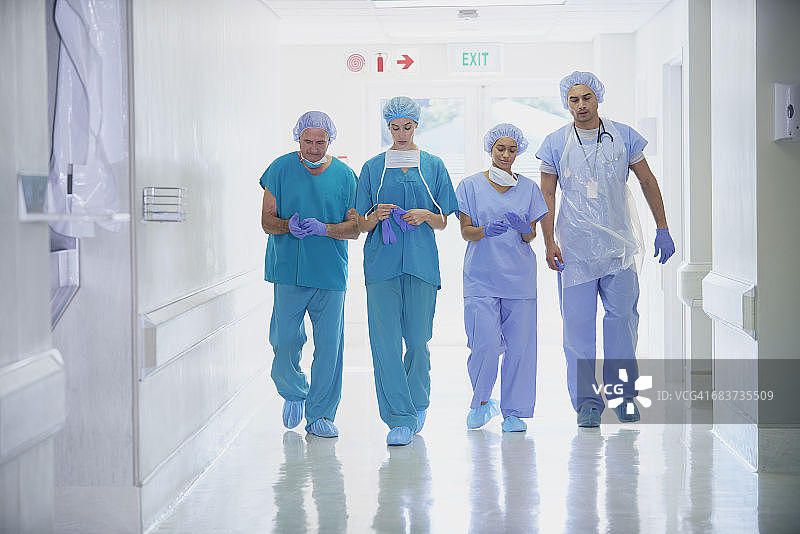 四名穿着手术服的医护人员走在医院走廊上图片素材