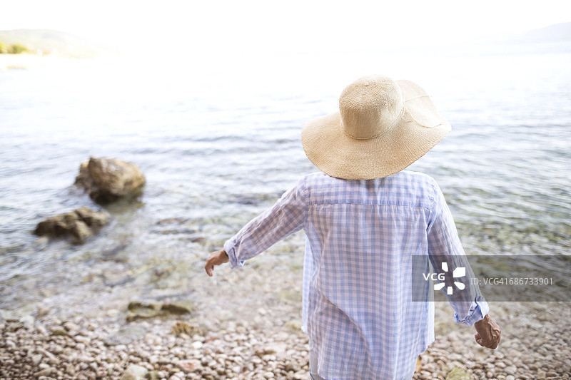 背景女子戴草帽站在海边图片素材