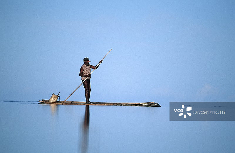渔民撑着独木舟图片素材