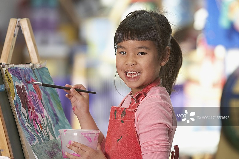 年轻的亚洲女孩在画架上作画图片素材