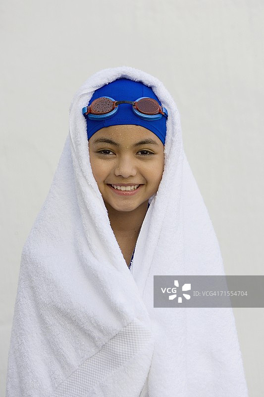 披着毛巾戴着游泳帽和护目镜的西班牙女孩图片素材